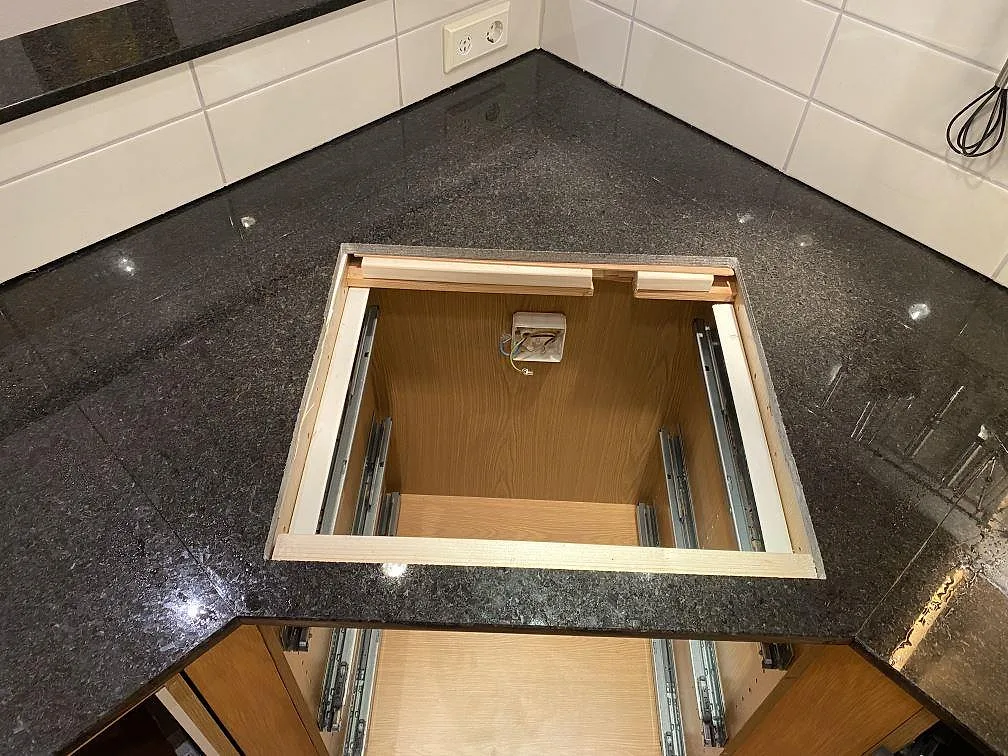 Polerad Angola Black granit runt en stor öppning i köksstommen, med svart stenyta och vitt kakel i Hässleholm.