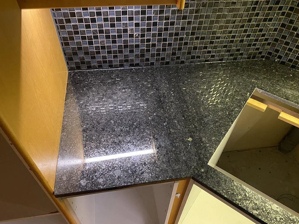 Detalj av polerad Angola Black granit i hörn vid öppning för häll i ett kök i Höllviken.