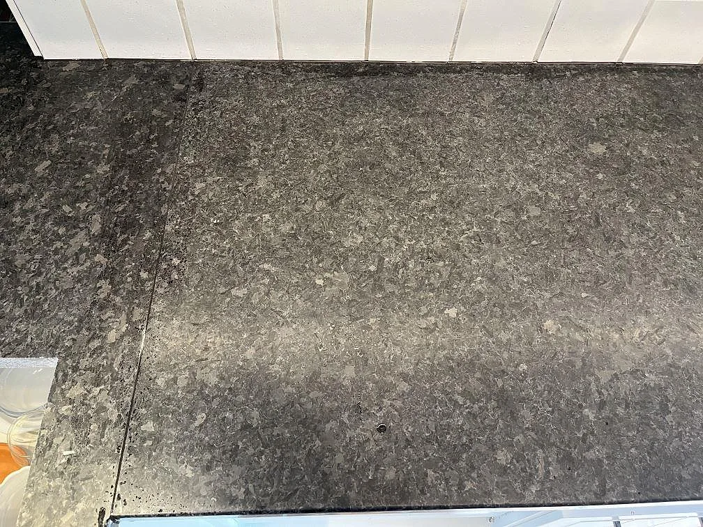 Närbild på köksbänkskiva i Angola Black svart granit i ett kök i Listerby.