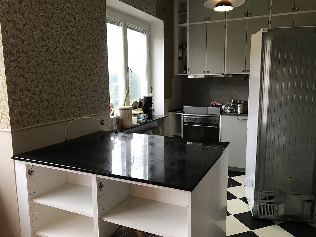 Polerad köksbänkskiva i svart Angola Black-granit monterad på en kökshalvö i ett kök i Malmö, fotograferad under montering.
