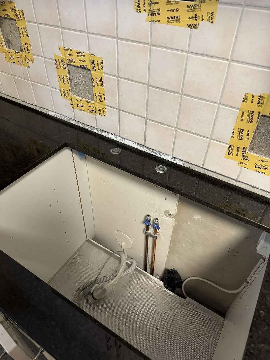 Detalj av polerad Angola Black granit vid köksbänkens kant och blandarhål under montering i Malmö.