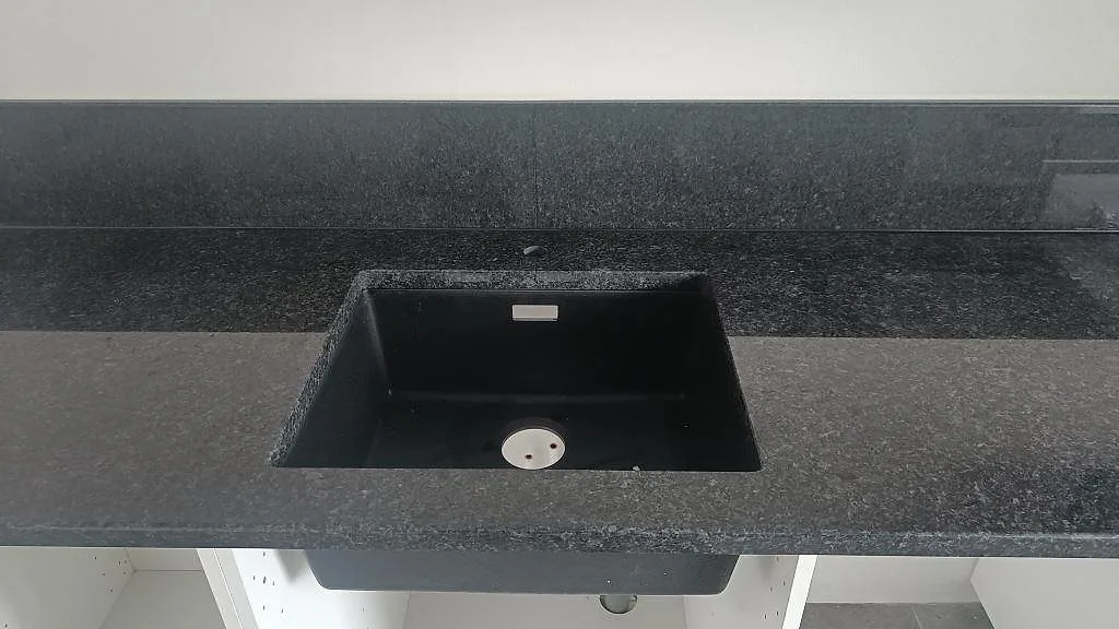 Detalj av urtag för häll i svart Angola Black granitbänk i ett kök i Staffanstorp.