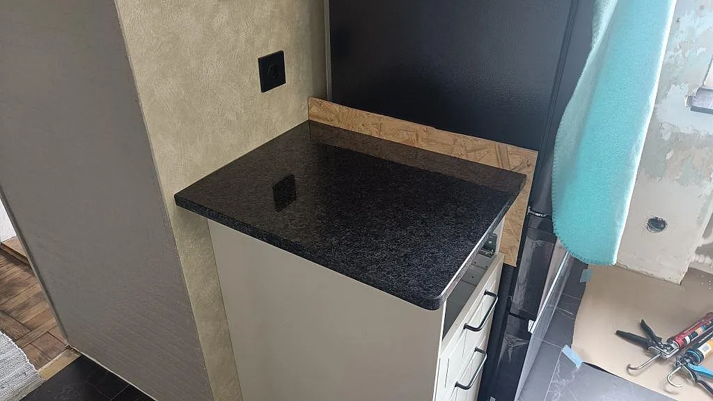 Sidobänk i polerad Angola Black granit med rundad framkant under pågående montering i Tomelilla.