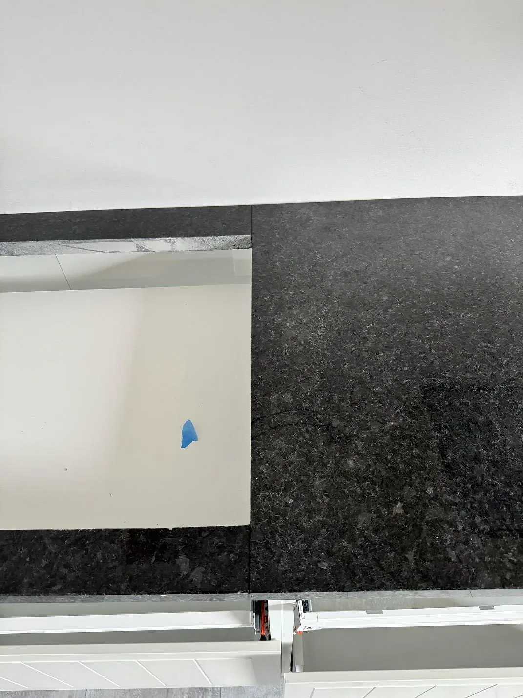 Ytdetalj av mörk Angola Black granit, 30 mm polerad, monterad som köksbänkskiva i Vellinge.