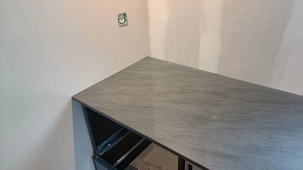 Installerad köksbänkskiva i polerad Anthracite Elegante granit på öppna köksstommar i Frillesås.