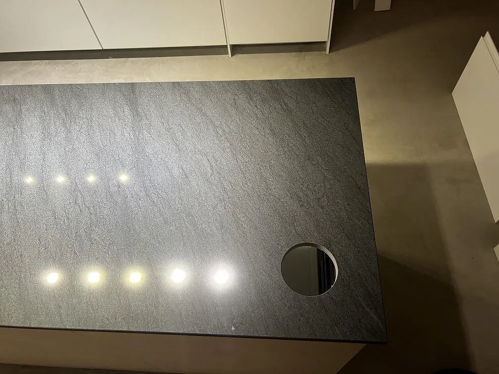 Närbild av köksö i polerad Anthracite Elegante granit med rund håltagning och mörk ådring i Malmö.