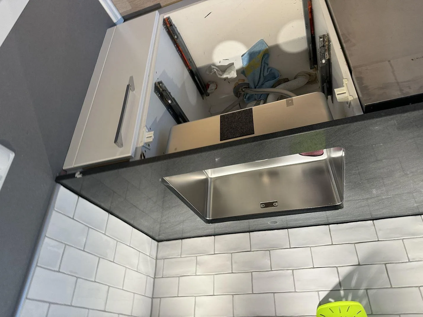 Översikt av mörk köksbänkskiva i polerad Anthracite Elegante granit med rostfri diskho under montering i Partille.