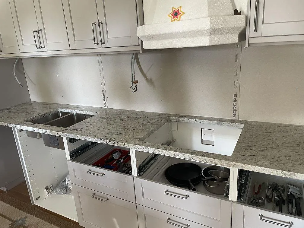 Köksbänkskiva i polerad Antique White granit med diskho och öppning för häll under montering i Hallstavik.
