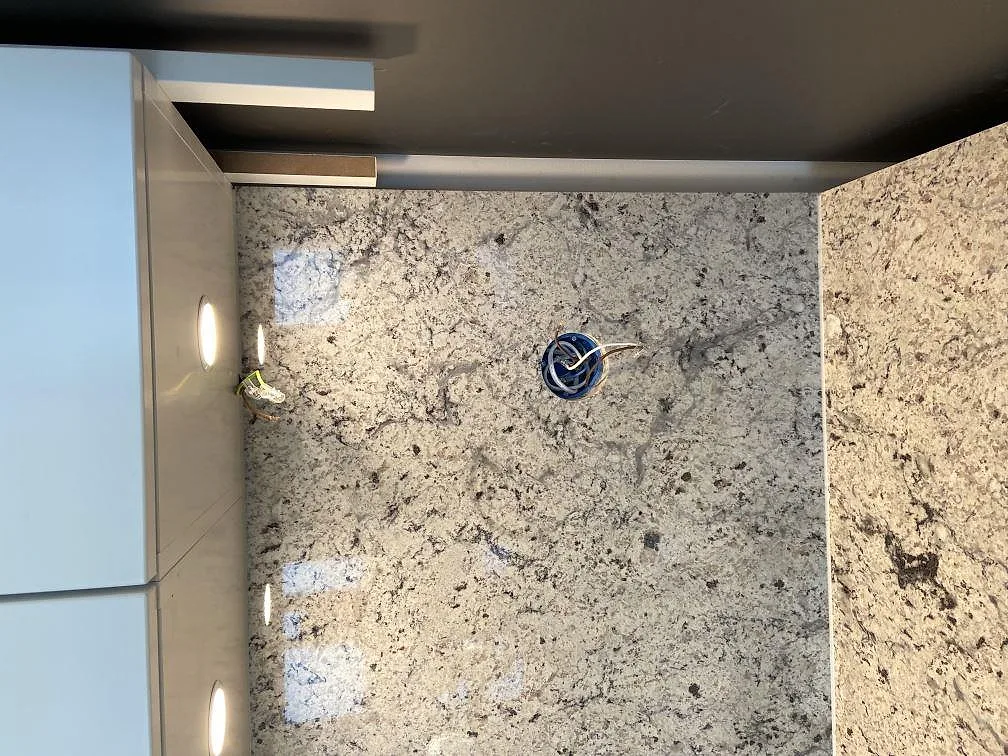 Polerad Antique White granitbänkskiva med blandarehål och fin spräcklig struktur i ett kök i Höllviken.