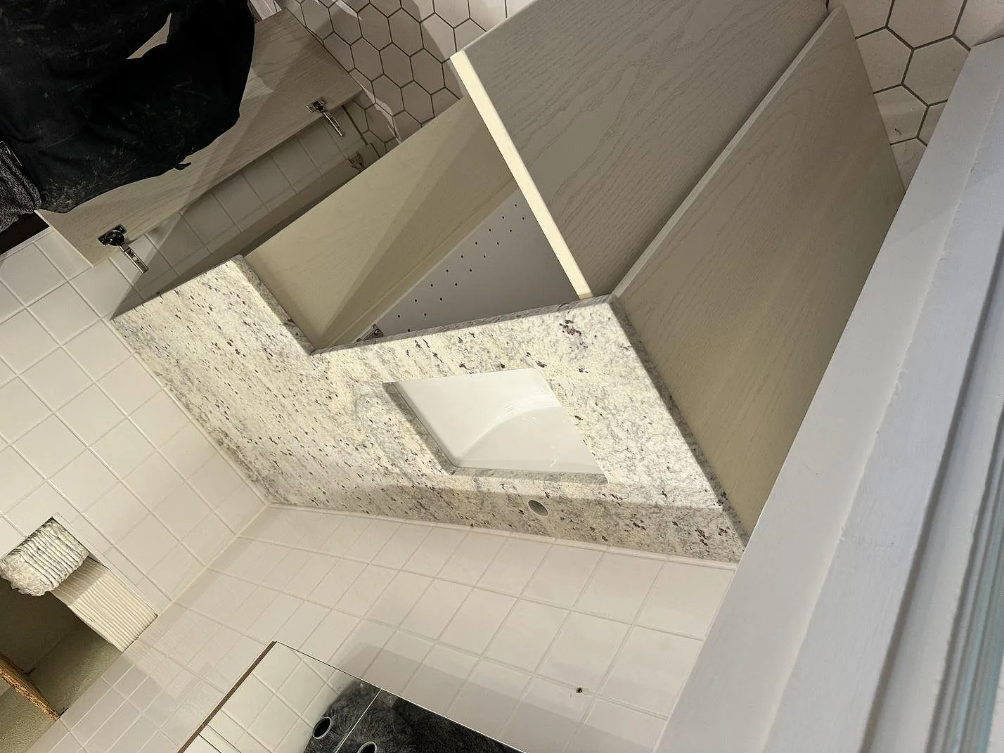 Badrumsbänkskiva i matt Antique White granit med vit underlimmad tvättställsskål i Malmö.