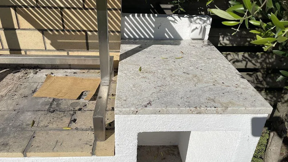 Närbild på matt bänkskiva i Antique White granit vid grilldelen i ett utekök i Skanör.