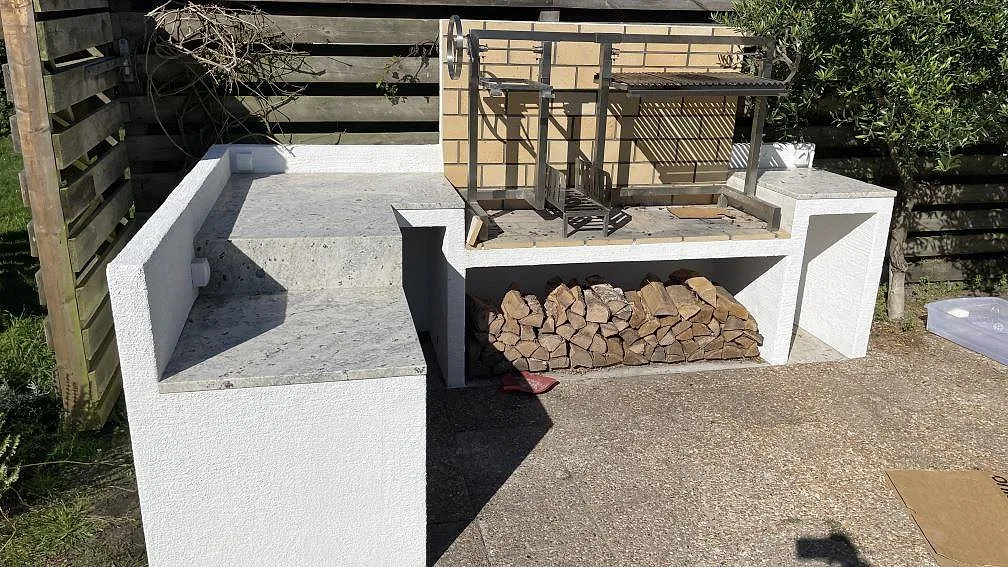 Utekök i Skanör med matt Antique White granit som bänkskiva runt grilldel och sidobänk.
