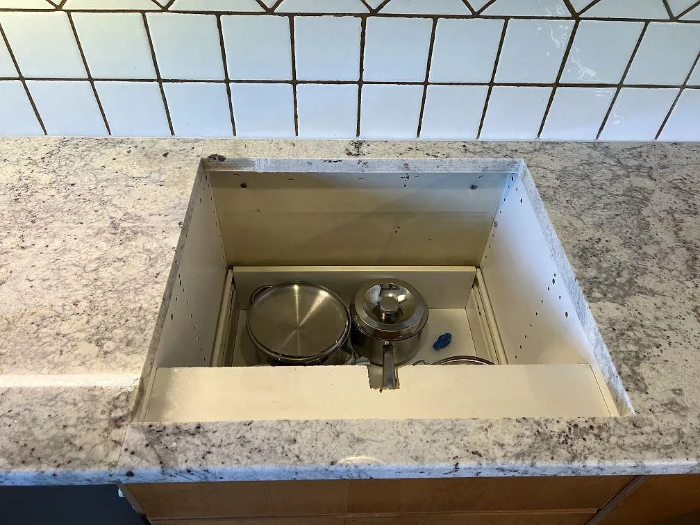 Hällurtag i köksbänkskiva av polerad Antique White granit med vit kakelvägg i Svedala.