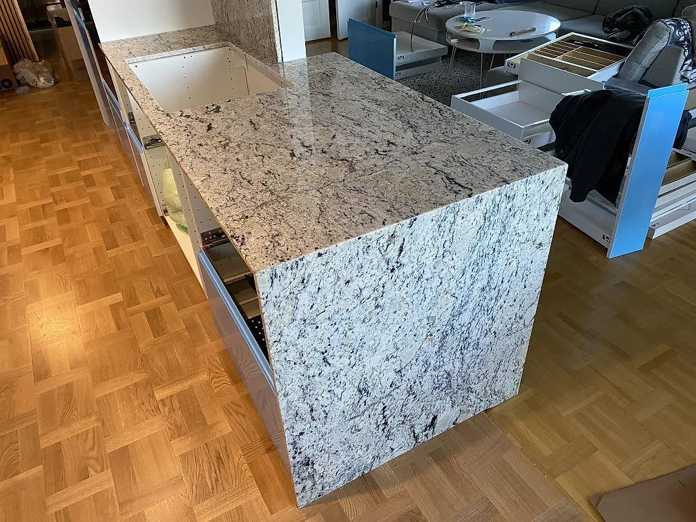 Närbild på polerad Antique White granit som köksbänkskiva med vattenfallssida och synlig stenstruktur i Svedala.
