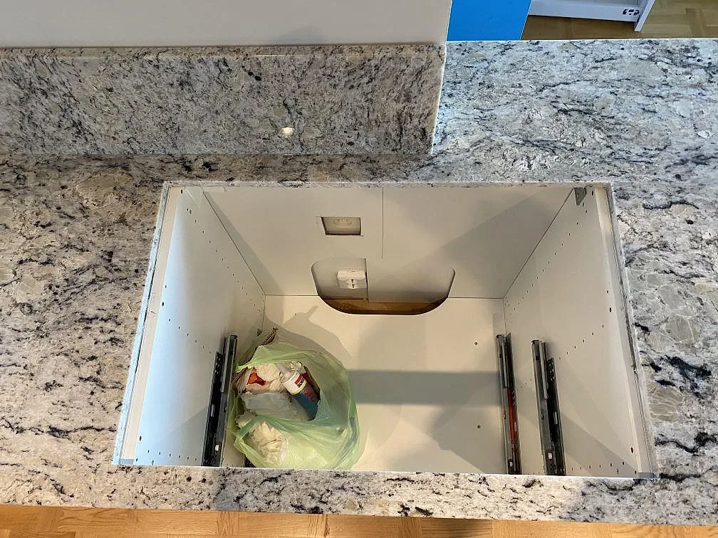 Topvy av polerad Antique White granit med stänkkant och öppna köksstommar under montering i Svedala.