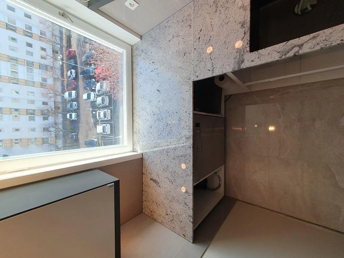 Översikt över polerad Antique White granit vid fönster och diskho i ett kök i Täby.