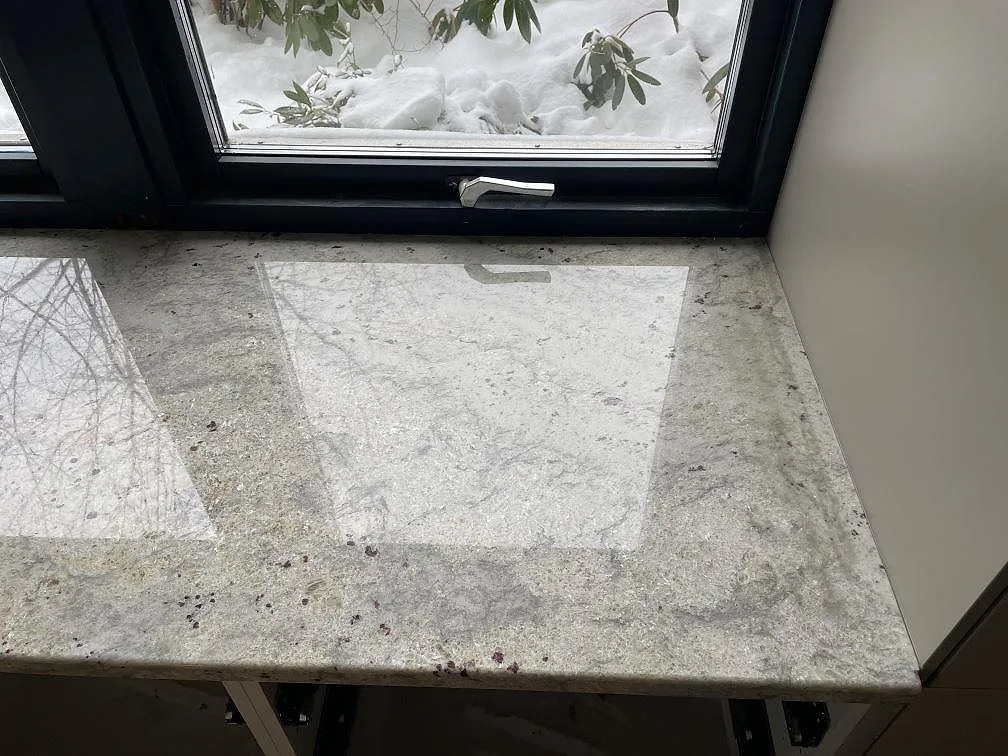 Fönsterbänk i Antique White granit, polerad, med spegelblank yta och naturlig stenstruktur i ett kök i Trollhättan.