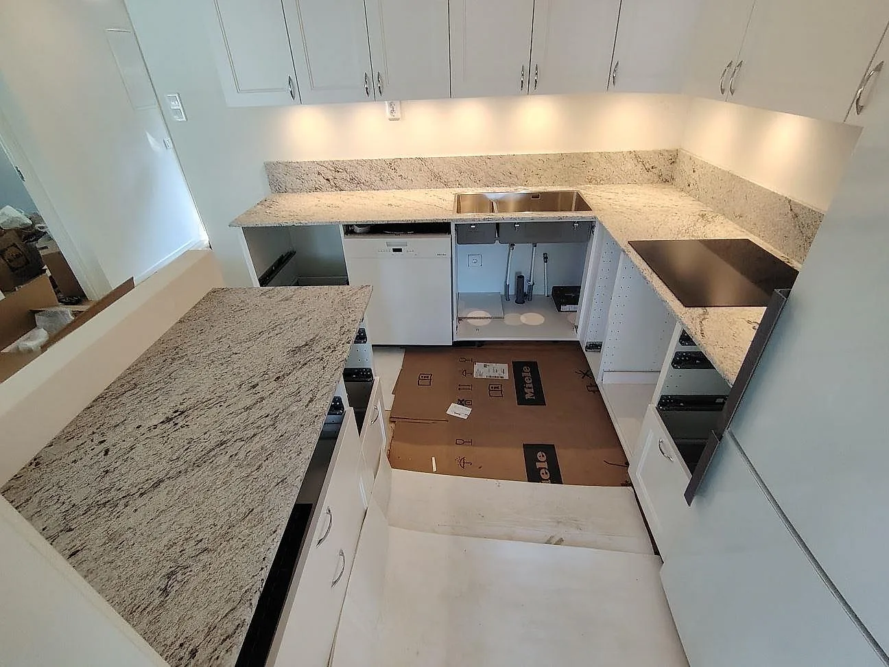 Matt köksbänkskiva i Antique White, granit, med uppvikt stänkskydd och ljusa köksstommar i Tyresö.