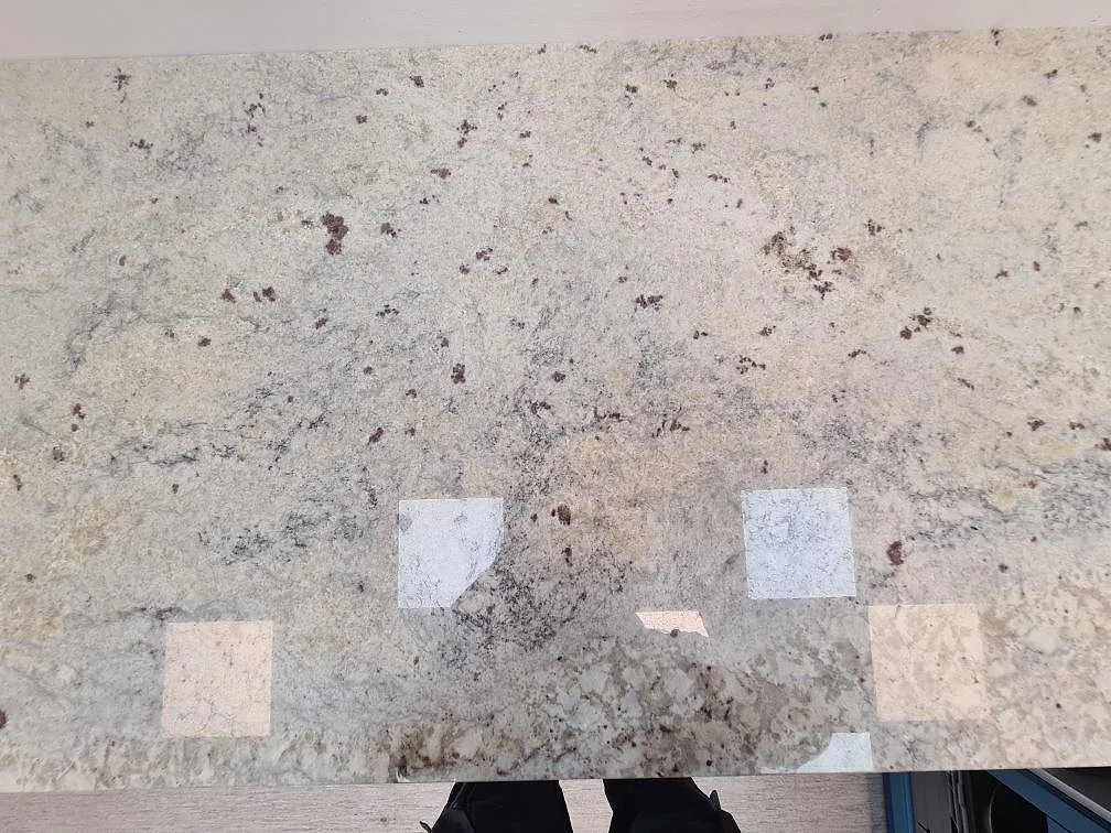 Topvy av polerad Antique White granit på köksbänkskiva med tydliga mineralinslag och ljusreflexer i Uppsala.