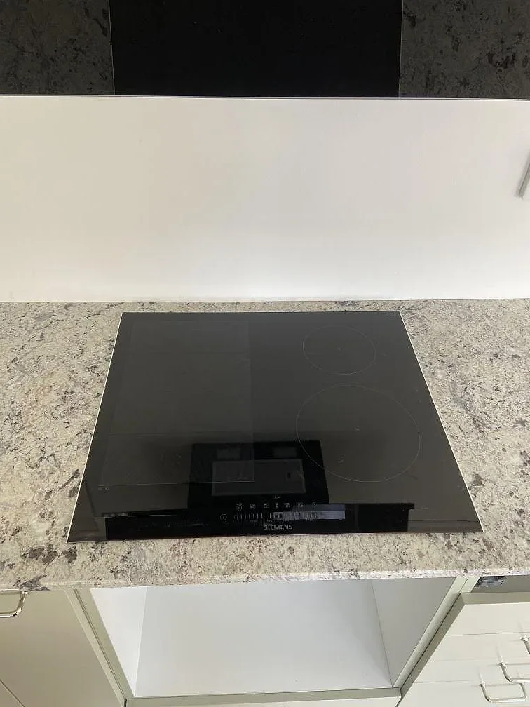 Infälld Siemens induktionshäll i polerad Antique White-granit på en köksbänkskiva i Växjö.