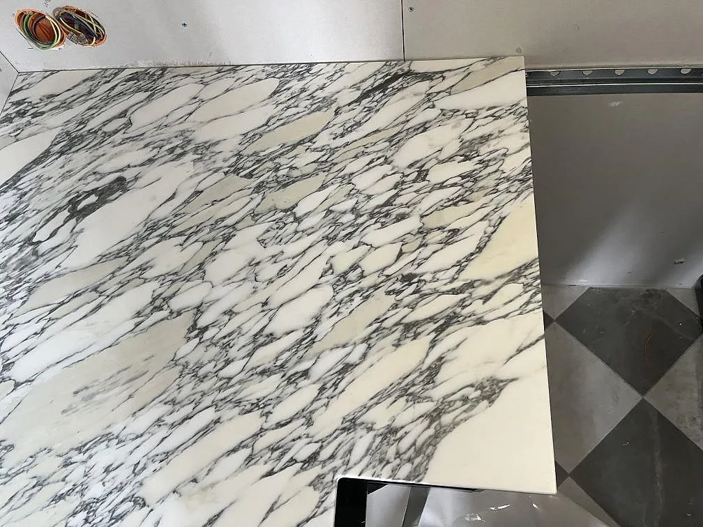 Detalj av matt Arabescato köksbänkskiva med levande grå ådring vid kökets hörn i Lidingö.
