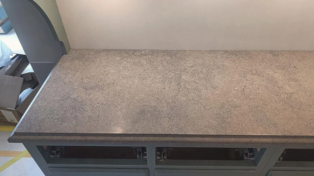 Detalj av matt Azul Valverde-marmor med profilerad framkant på köksbänk under montering i Barsebäck.