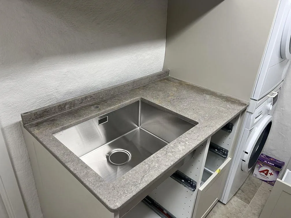 Närbild på matt Azul Valverde marmorbänkskiva med diskho och uppvikt stänkkant i Bromma.