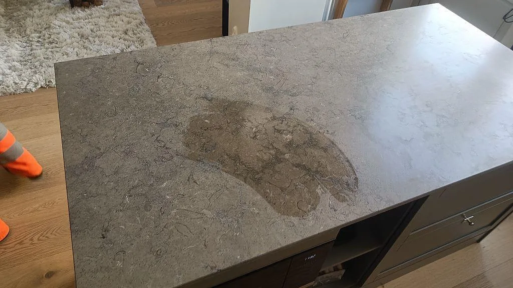 Närbild på matt Azul Valverde marmor på köksö med grå ådring och bearbetad kant i Göteborg.