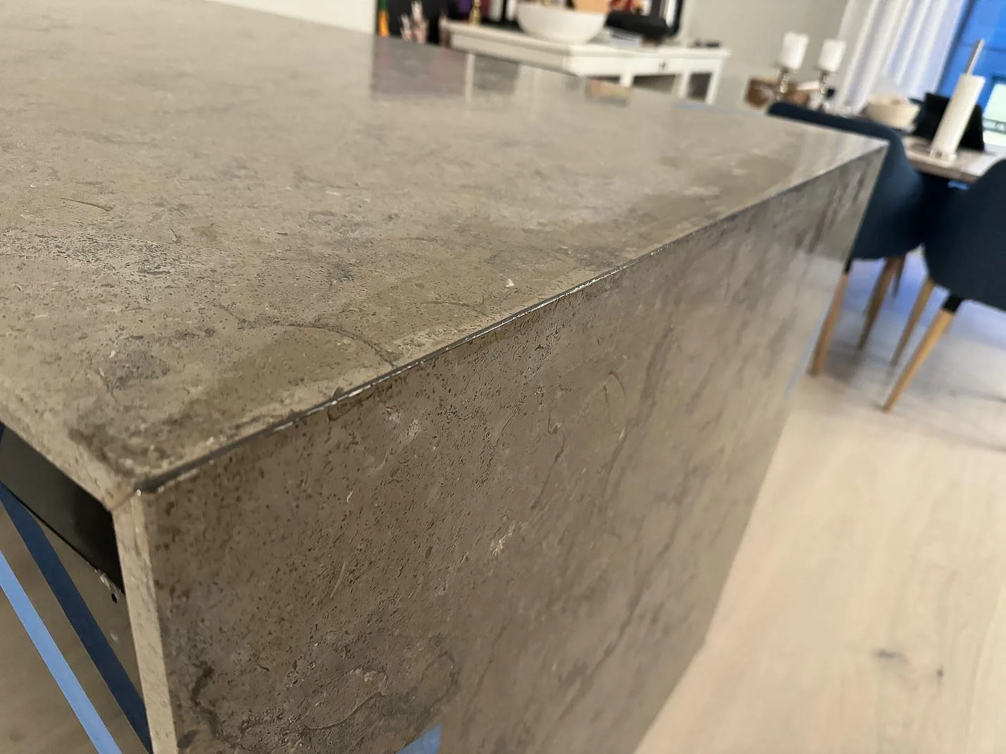 Detalj av matt Azul Valverde med grå fossil ådring och polerad kant på en köksö i Göteborg.