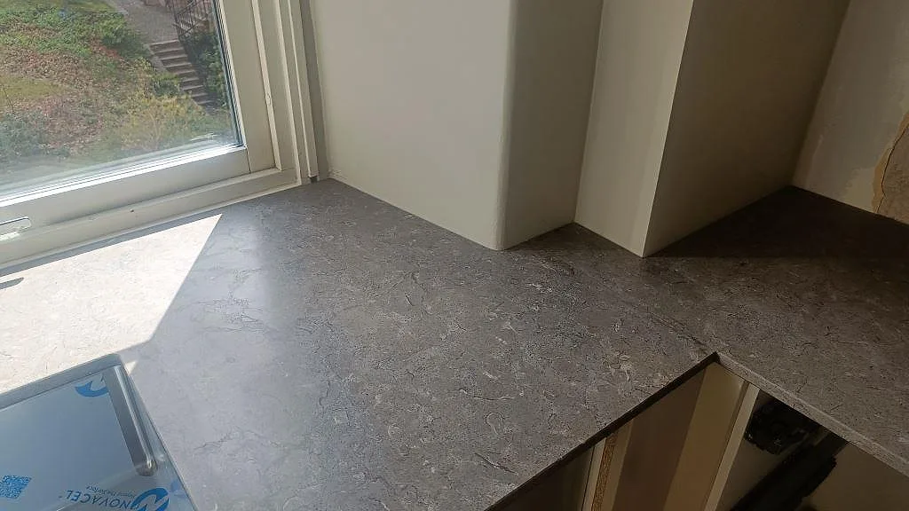 Hörn och arbetsyta i grå Azul Valverde marmor, matt, med naturlig ådring i ett kök i Göteborg.