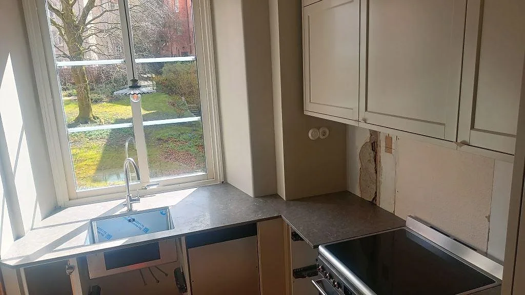 Köksbänkskiva i grå Azul Valverde marmor, matt, med underlimmad diskho och svart häll i Göteborg.
