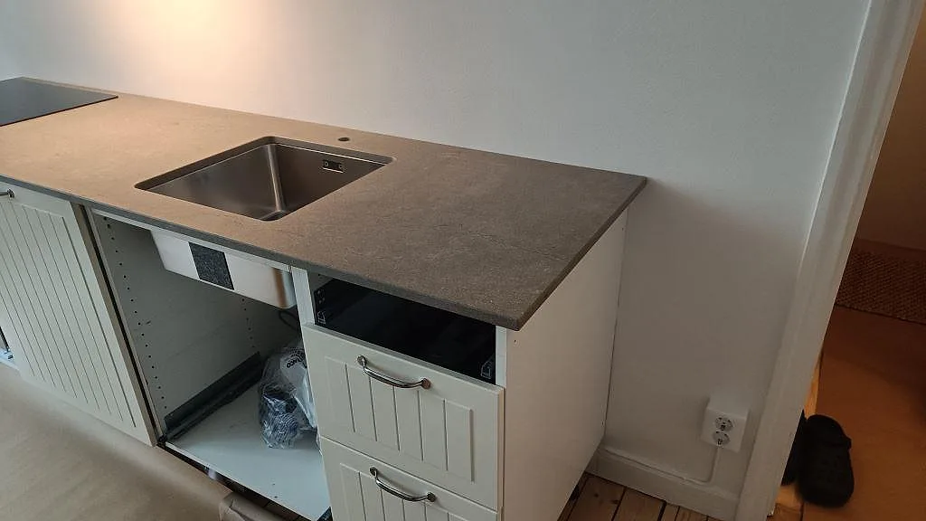 Närbild på matt Azul Valverde marmor som köksbänkskiva med rostfri diskho och öppen köksstomme i Göteborg.