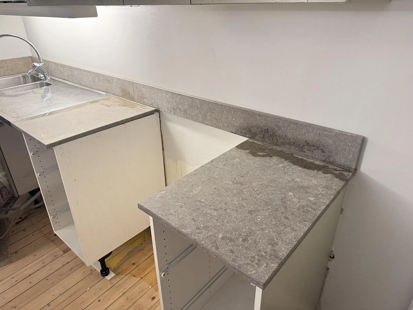 Kök med bänkskivor och uppvikt stänkkant i matt Azul Valverde marmor längs väggsidan i Göteborg.