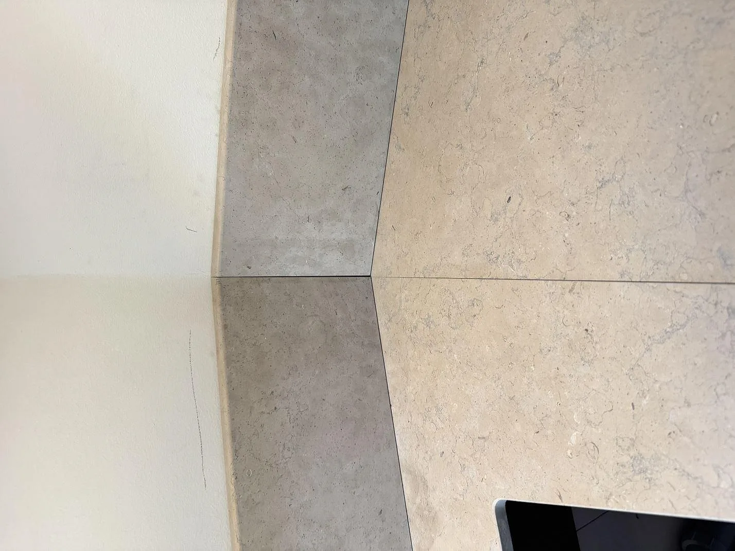 Detalj av bänkskiva i matt Azul Valverde marmor med uppvikt stenkant och synlig fossil ådring i Göteborg.
