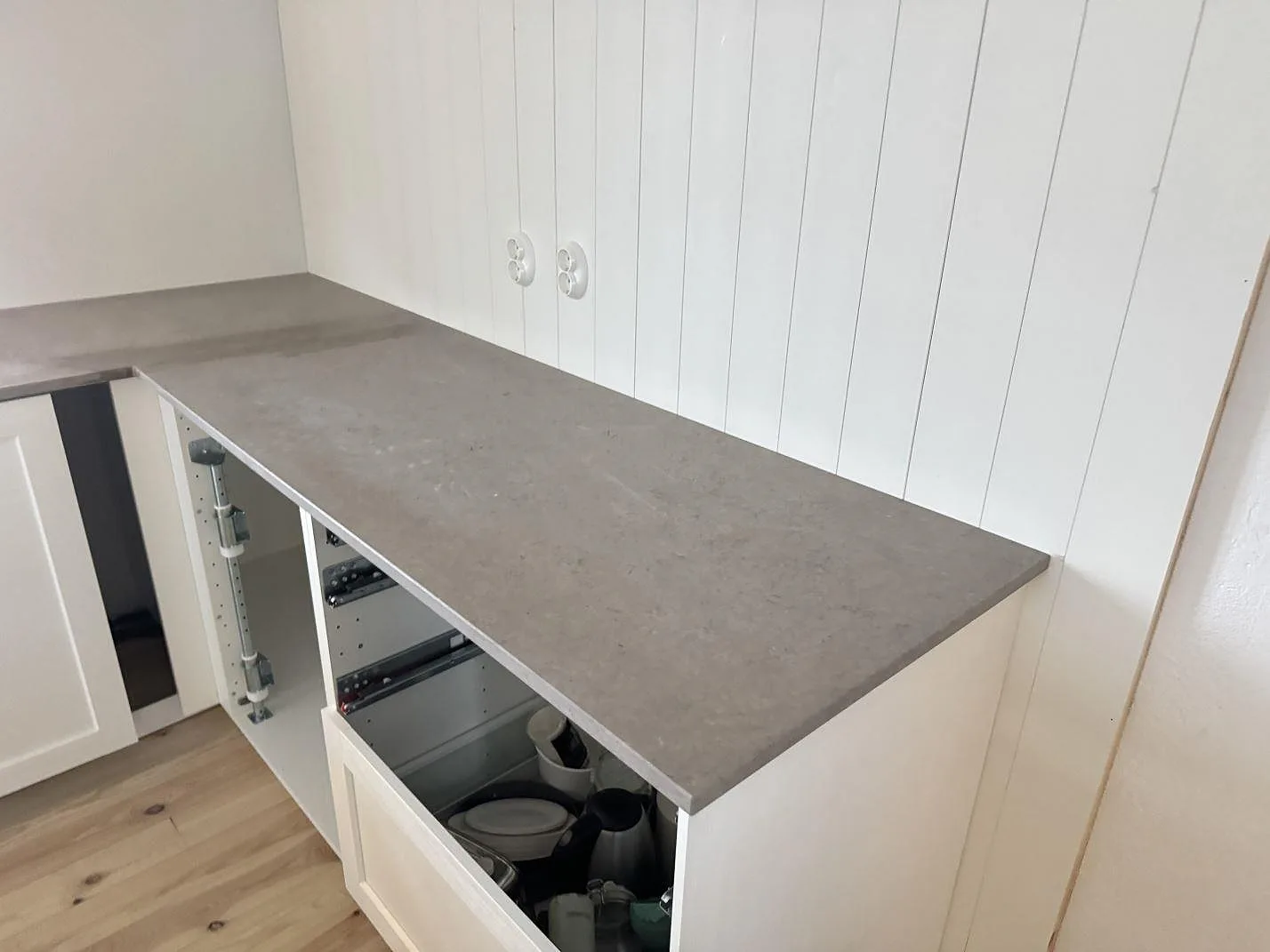 Vinklad köksbänkskiva i matt Azul Valverde mot en vägg av vit pärlspont i ett kök i Kristianstad.