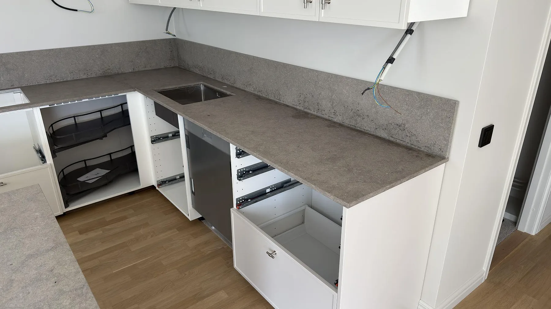 Rak bänkskivelängd i matt Azul Valverde marmor med uppvikt stänkskydd och synlig stenstruktur i kök i Sundbyberg.