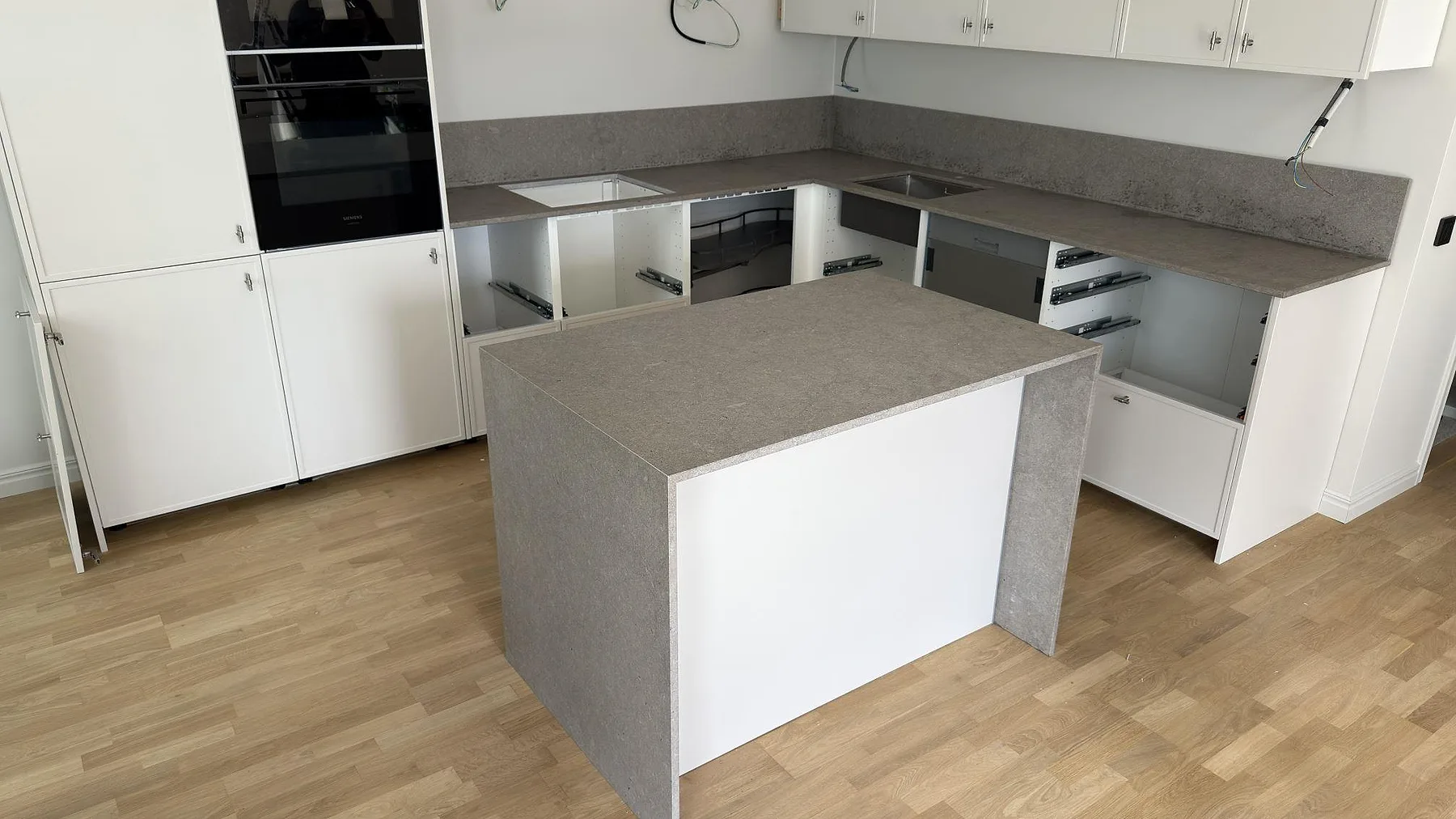 Köksbänkskiva och köksö i matt Azul Valverde marmor med stänkskydd i ett kök i Sundbyberg.