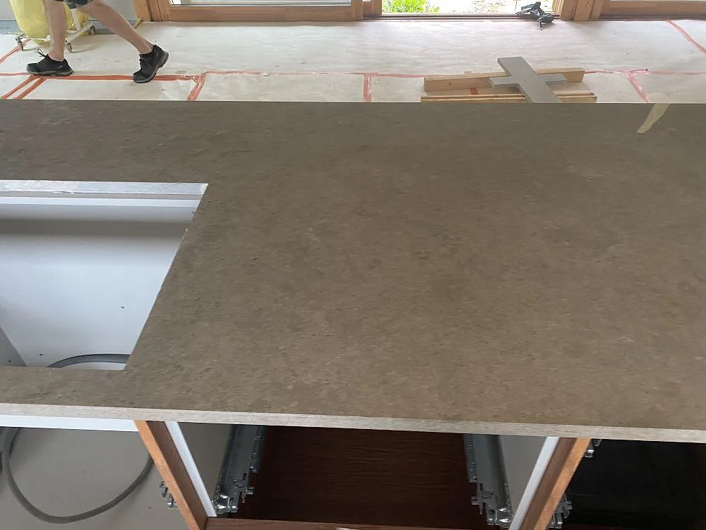 Installerad bänkskiva i matt Azul Valverde marmor med utskärning och trästommar i ett kök i Växjö.