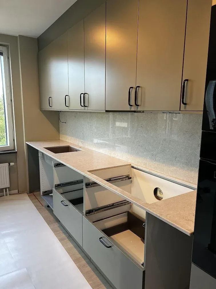 Polerad bänkskiva i Bianco Drift komposit med matchande stänkskydd, diskhoöppning och öppna köksstommar i Limhamn.