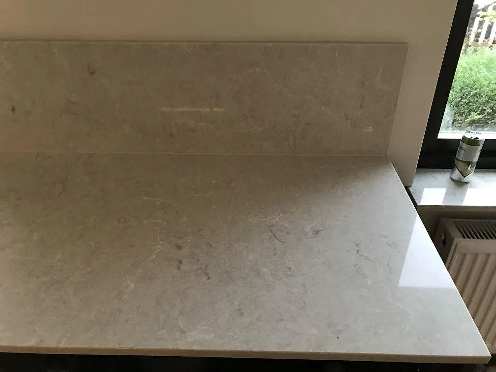 Närbild på underlimmad rostfri diskho med två kranhål i Bianco Drift köksbänkskiva i Lomma.