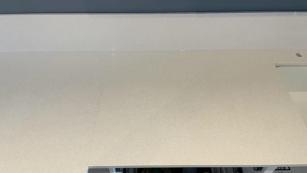Ljus Blanco Norte kompositbänkskiva med polerad yta och uppvikt stänkskydd längs väggen i Helsingborg.