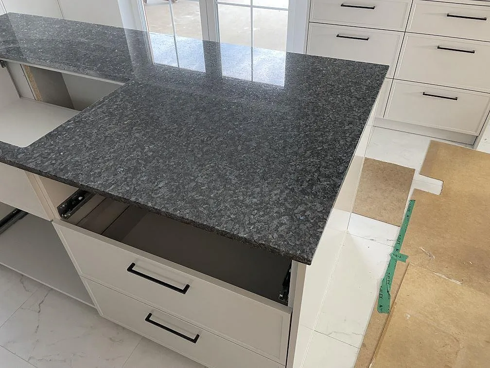 Detalj av polerad Blue Pearl granit på köksö, 20 mm, med mörk blågrå yta och ljus kristallstruktur i Sölvesborg.