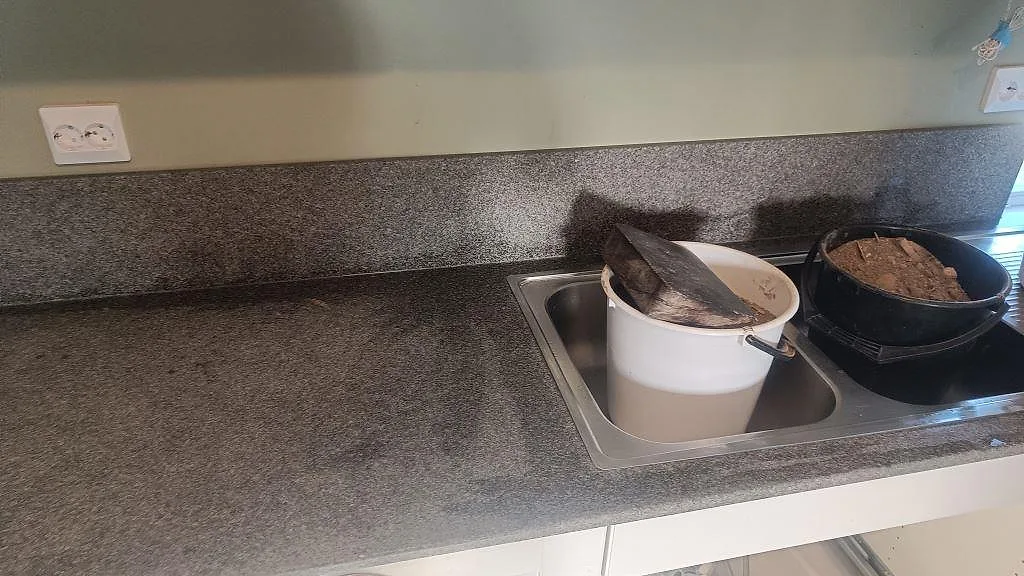 Installerad köksbänkskiva i Bohus Grå granit med rostfri diskbänkszon och uppvikt stänkkant i Brantevik.