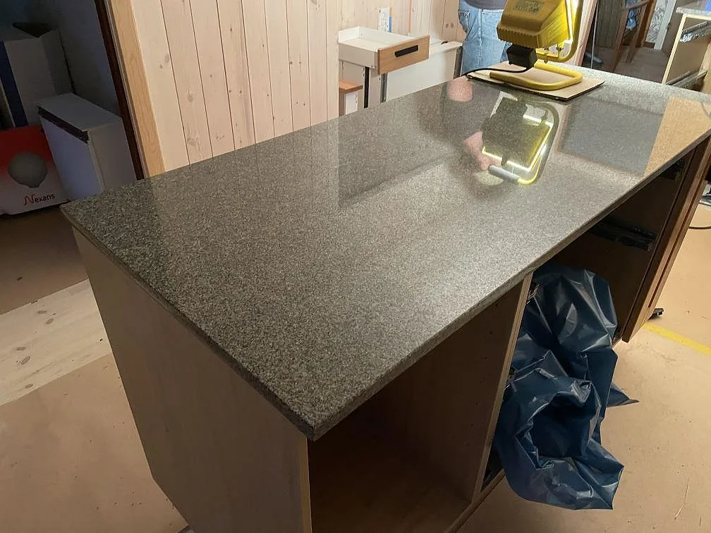 Stor köksö i polerad Bohus Grå granit på trästommar under montering i Dannike.