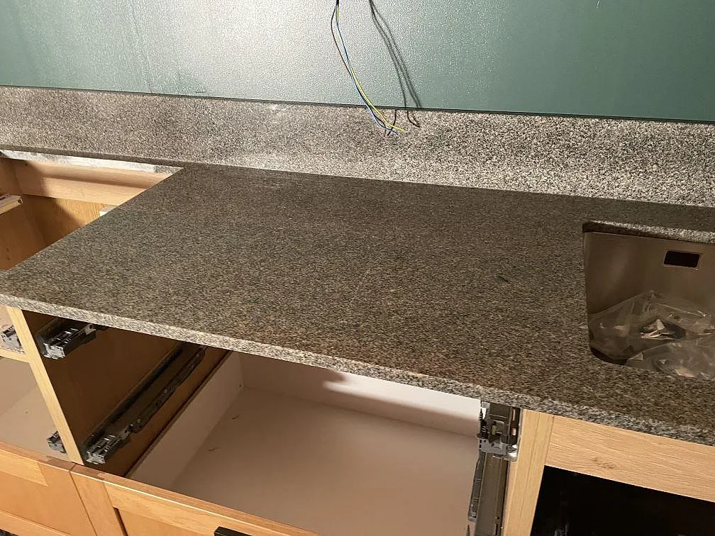 Polerad Bohus Grå granitbänkskiva med rostfri underlimmad diskho och stänkkant i ett kök i Dannike.