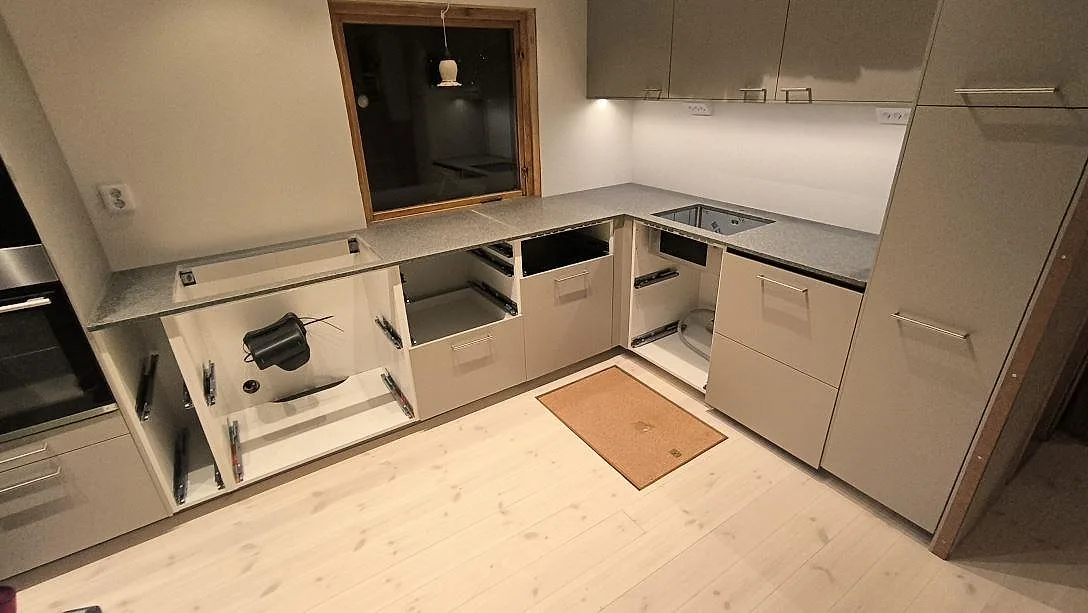 Köksbänkskiva i Bohus Grå granit, matt, monterad som L-formad arbetsyta i ett kök i Djurhamn.