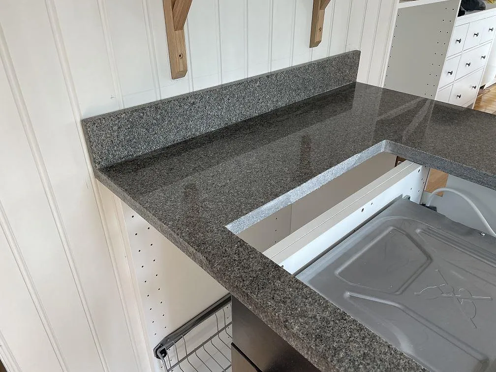 Hörn av köksbänkskiva i Bohus Grå granit med polerad yta och öppna stommar i Göteborg.