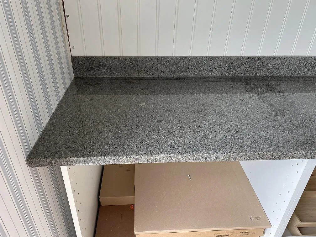 Rak bänkskiva i Bohus Grå granit, polerad, monterad på vita köksstommar i Göteborg.