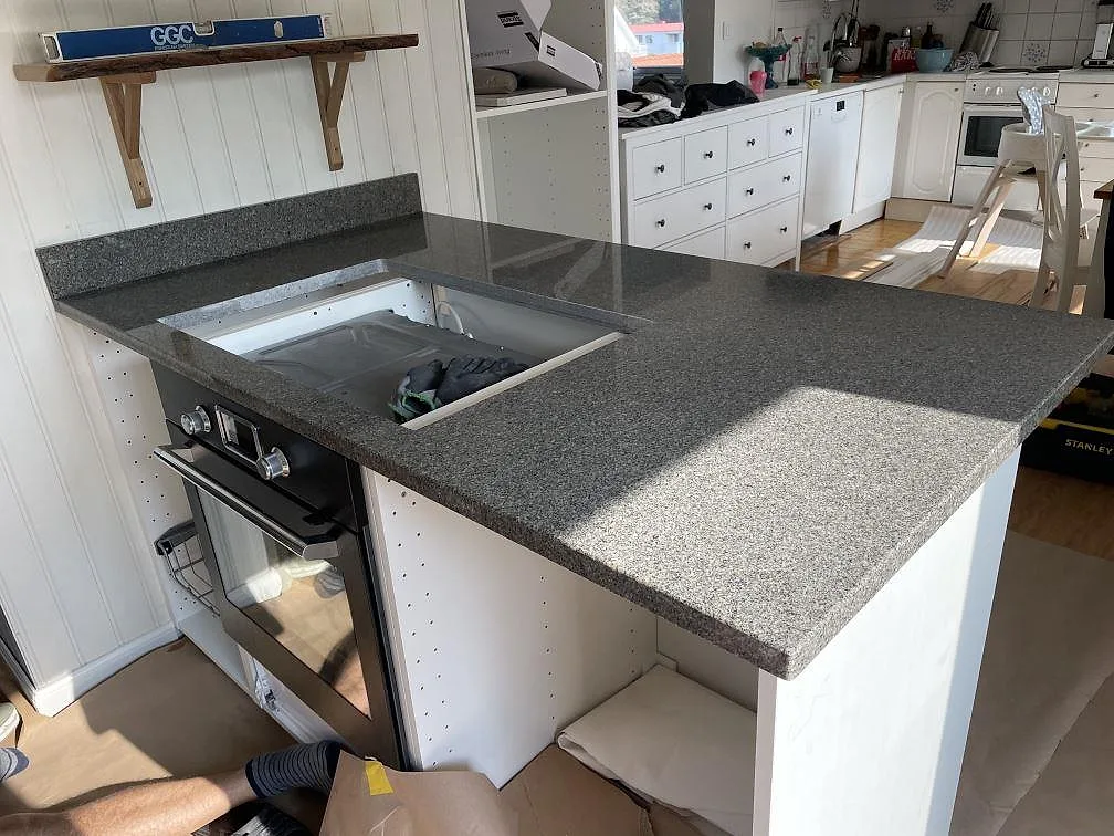 Halvö i polerad Bohus Grå granit med spisöppning och uppvikt stänkkant i kök i Göteborg.