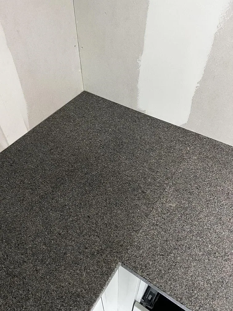 Detalj av hörn och skarv i en matt Bohus Grå granitbänkskiva i Lerum.